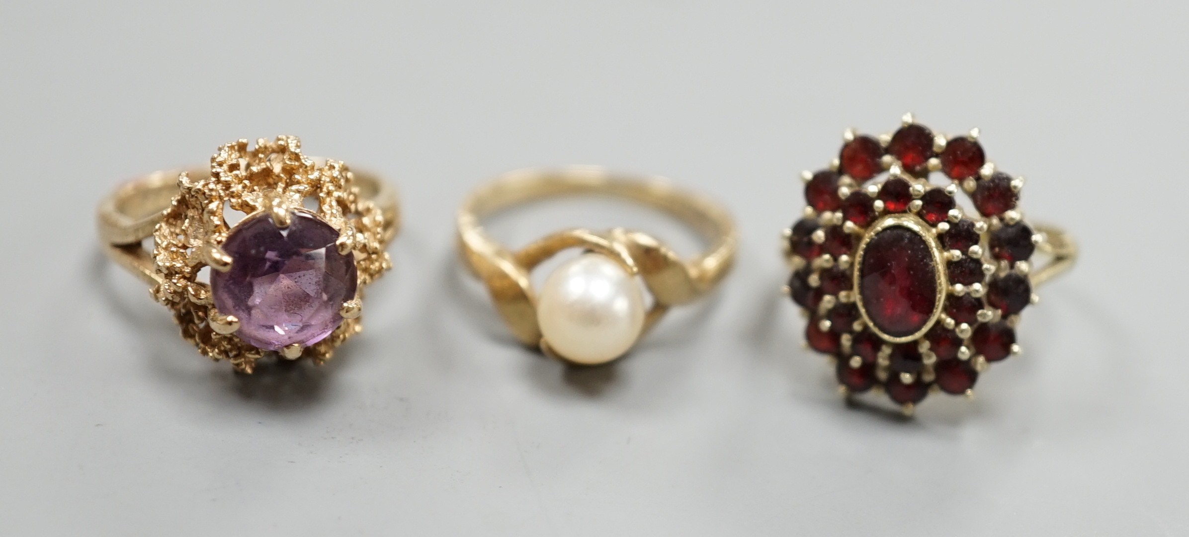 Two modern 9ct gold dress rings, one set with cultured pearl, the other with amethyst, gross weight 6.5 grams and an Austro-Hungarian yellow meta and garnet cluster ring, gross 4.4 grams.